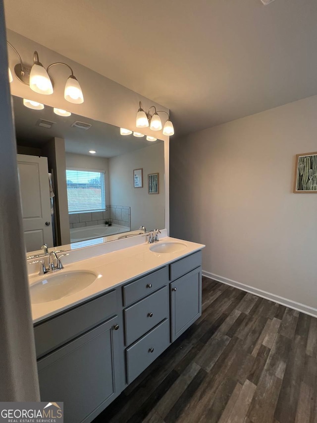 bathroom with hardwood / wood-style floors, vanity, and a washtub