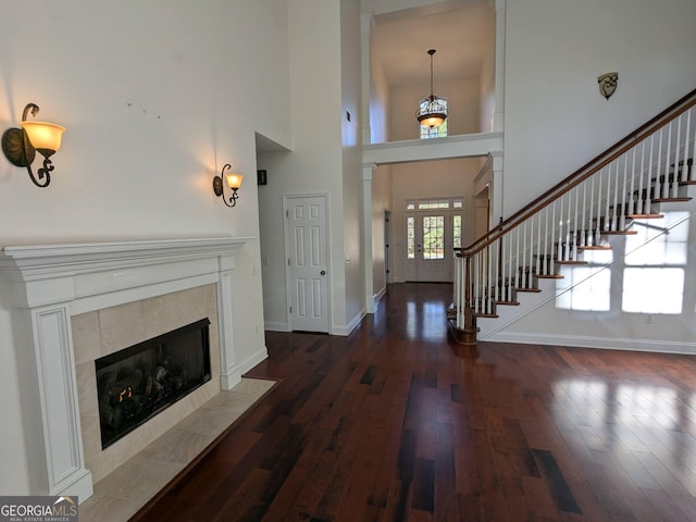 foyer featuring dark hardwood / wood-style flooring, a fireplace, and a high ceiling