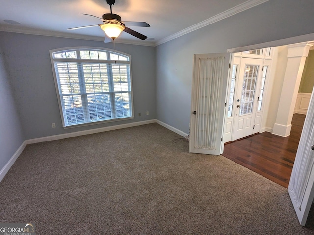 spare room featuring crown molding, ceiling fan, and dark carpet