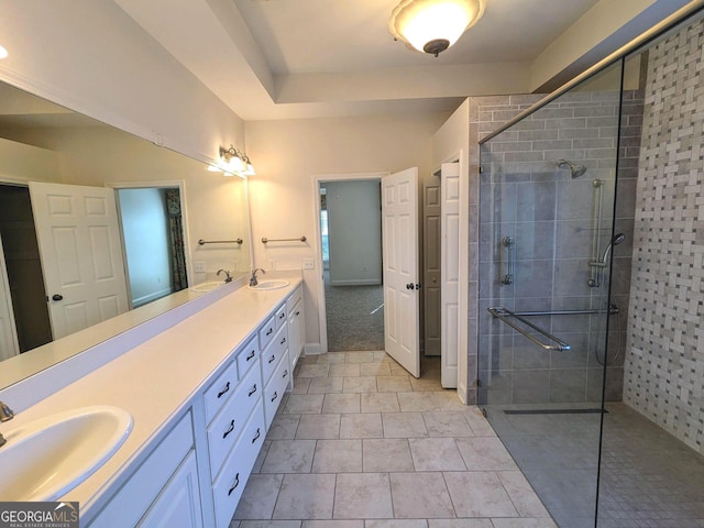 bathroom featuring tiled shower, vanity, and tile patterned flooring