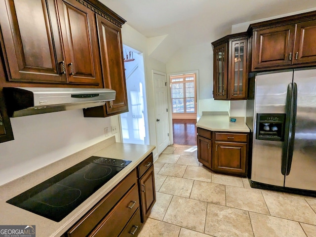 kitchen with stainless steel fridge with ice dispenser, extractor fan, lofted ceiling, black electric stovetop, and light tile patterned floors