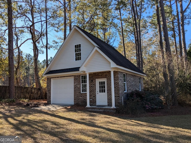 view of front property with a front yard, a garage, and an outdoor structure