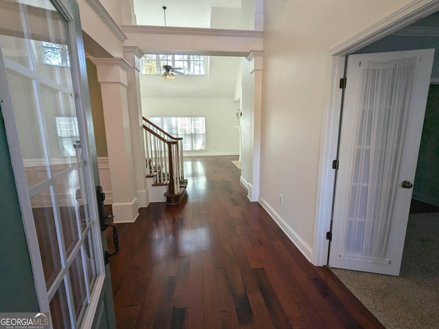 hallway featuring ornate columns and dark wood-type flooring