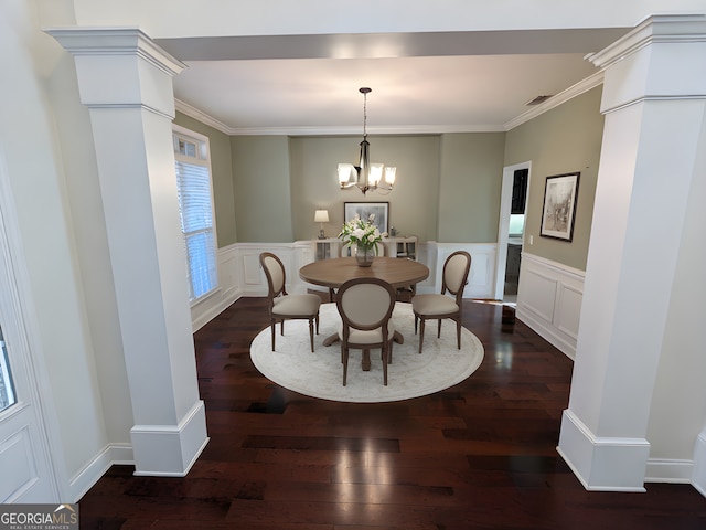 dining room featuring decorative columns, dark hardwood / wood-style flooring, ornamental molding, and a chandelier