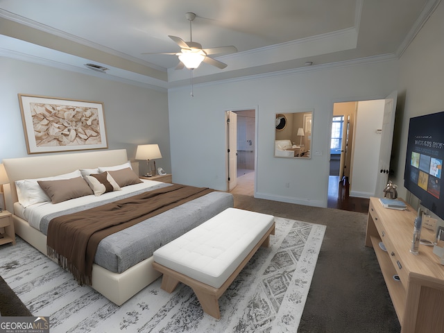 bedroom with a raised ceiling, ensuite bath, ceiling fan, and ornamental molding