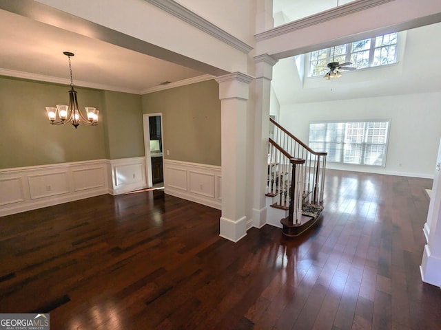 interior space with ceiling fan with notable chandelier, dark hardwood / wood-style flooring, and crown molding