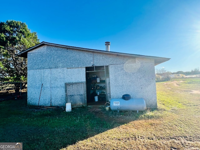 view of side of property with a yard and an outdoor structure