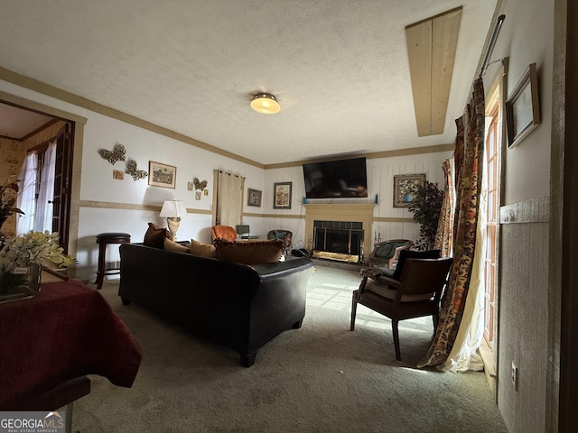 carpeted living room featuring a textured ceiling and a tile fireplace