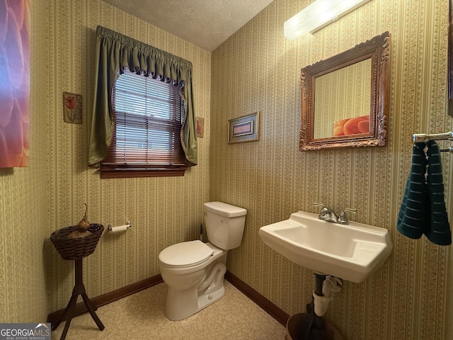 bathroom with toilet and a textured ceiling