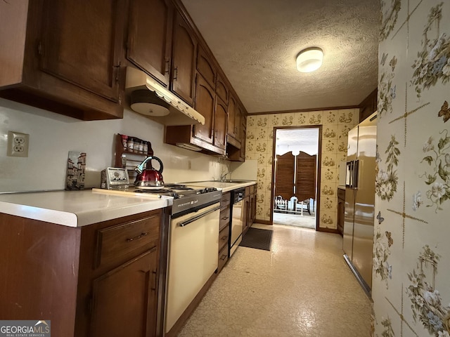 kitchen featuring high end fridge, gas range oven, a textured ceiling, dark brown cabinetry, and black dishwasher