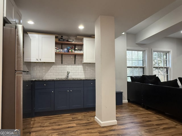 kitchen featuring stainless steel refrigerator, sink, dark hardwood / wood-style flooring, backsplash, and white cabinets