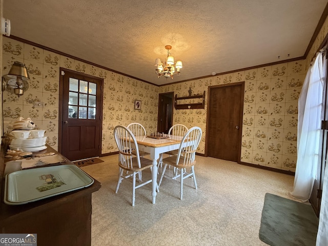 dining space with a chandelier, a textured ceiling, carpet floors, and ornamental molding