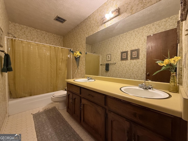 full bathroom featuring vanity, shower / bath combination with curtain, tile patterned flooring, toilet, and a textured ceiling