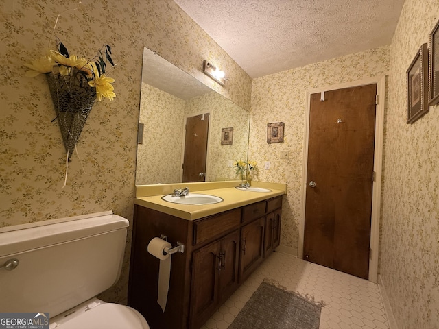 bathroom featuring vanity, tile patterned floors, a textured ceiling, and toilet