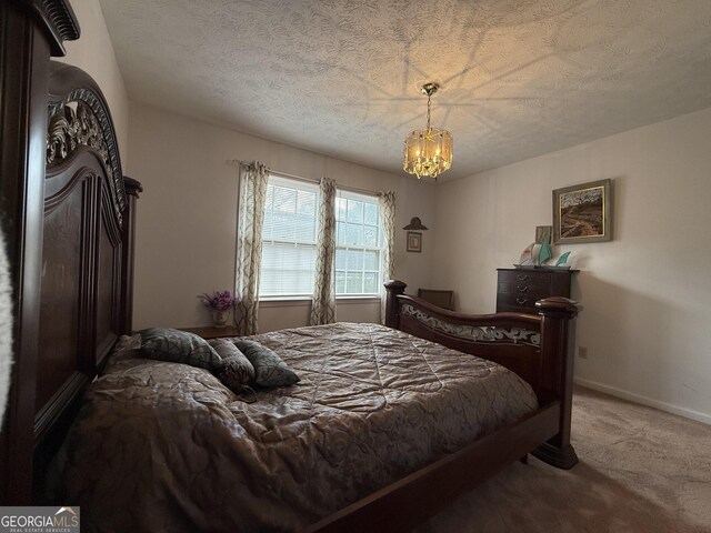 carpeted bedroom with a chandelier and a textured ceiling