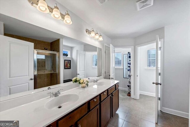 bathroom featuring tile patterned flooring, vanity, and a shower with shower door