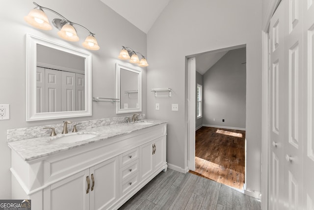 bathroom featuring lofted ceiling, hardwood / wood-style flooring, and vanity