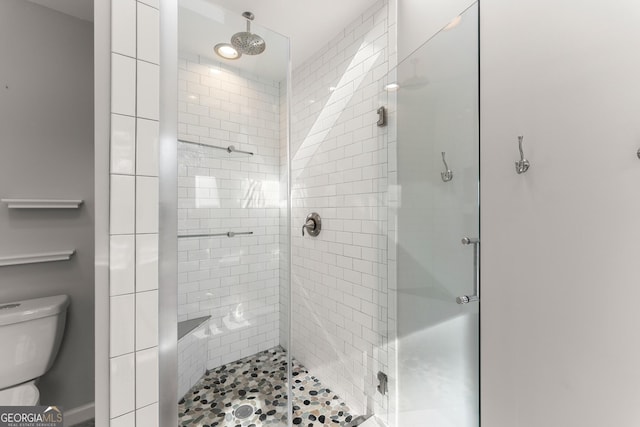 bathroom with toilet and an enclosed shower