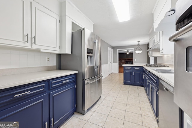 kitchen with hanging light fixtures, white cabinets, blue cabinets, light tile patterned flooring, and appliances with stainless steel finishes