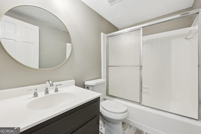 full bathroom featuring vanity, toilet, and bath / shower combo with glass door