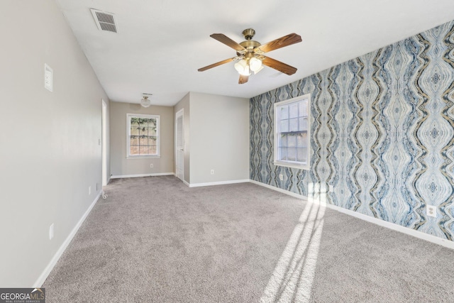 empty room featuring carpet flooring and ceiling fan