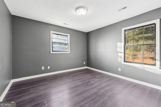 spare room featuring dark wood-type flooring