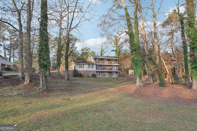 view of front of property with a balcony and a front lawn