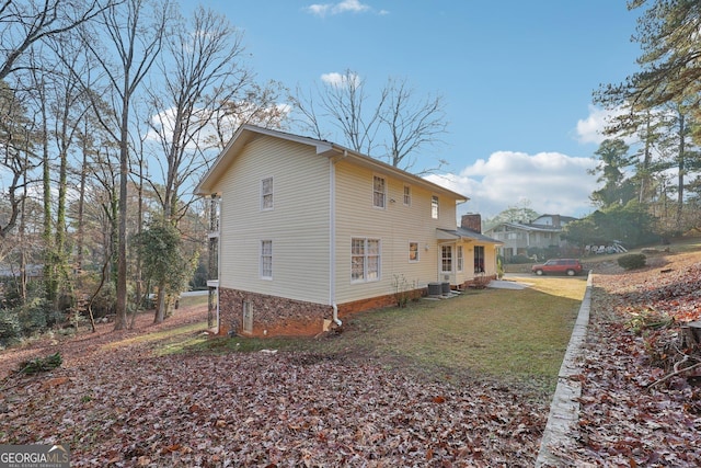 view of side of home with a lawn and central air condition unit