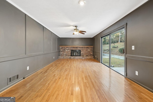 unfurnished living room with ceiling fan, light wood-type flooring, and a fireplace