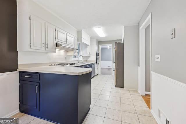 kitchen featuring blue cabinets, sink, light tile patterned floors, white cabinetry, and stainless steel appliances