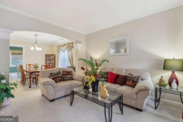 living room with a notable chandelier, crown molding, and decorative columns