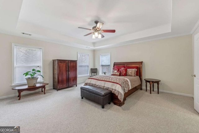 bedroom with multiple windows, a raised ceiling, and ceiling fan