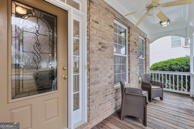 view of exterior entry featuring ceiling fan and a porch