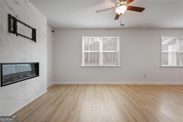 kitchen with light hardwood / wood-style flooring, decorative light fixtures, a center island with sink, white cabinets, and appliances with stainless steel finishes