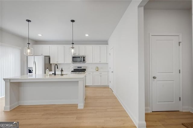 kitchen featuring white cabinetry, sink, stainless steel appliances, backsplash, and decorative light fixtures