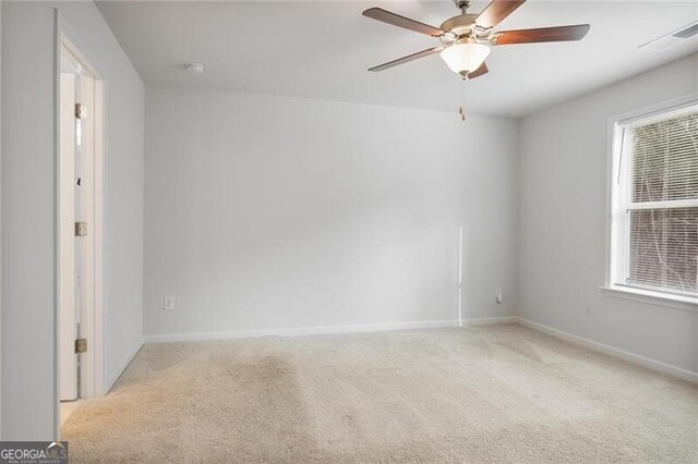 carpeted spare room with ceiling fan