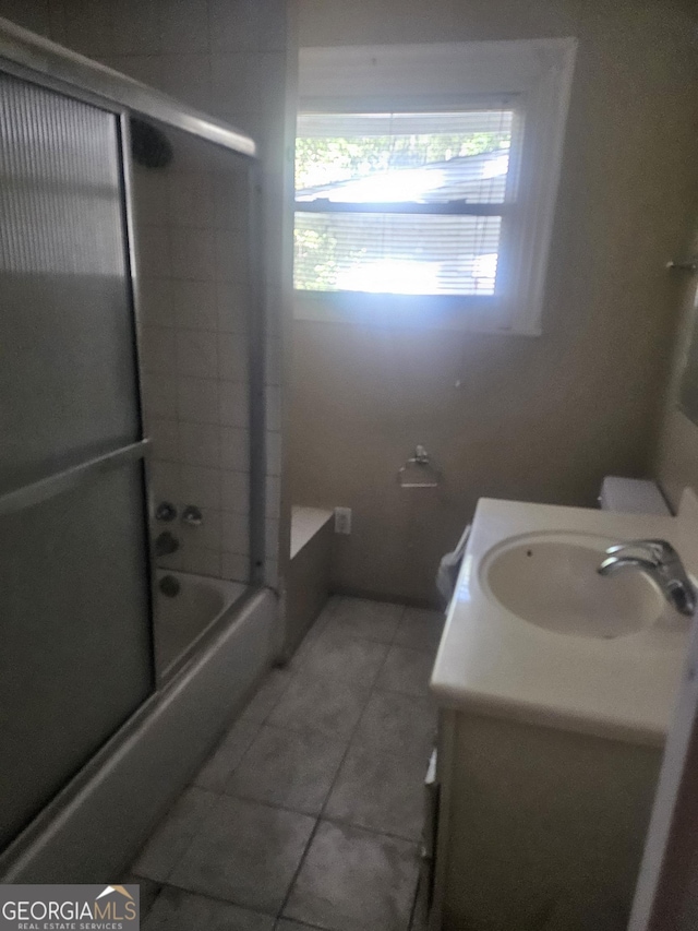 full bathroom with tile patterned flooring, vanity, combined bath / shower with glass door, and toilet