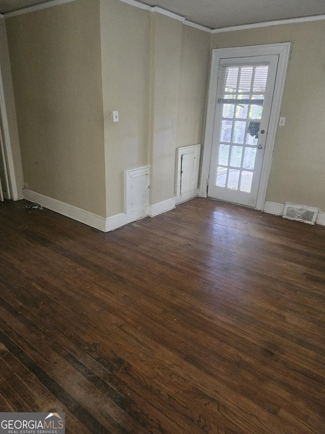 empty room with dark wood-type flooring and ornamental molding