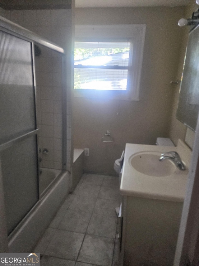 full bathroom featuring tile patterned flooring, vanity, toilet, and enclosed tub / shower combo