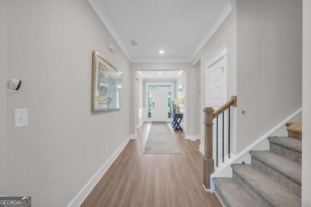 foyer entrance with light wood-type flooring and crown molding