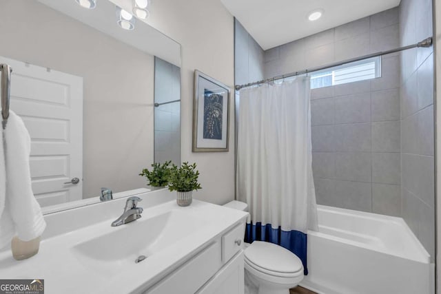 full bathroom featuring shower / bath combo with shower curtain, vanity, and toilet