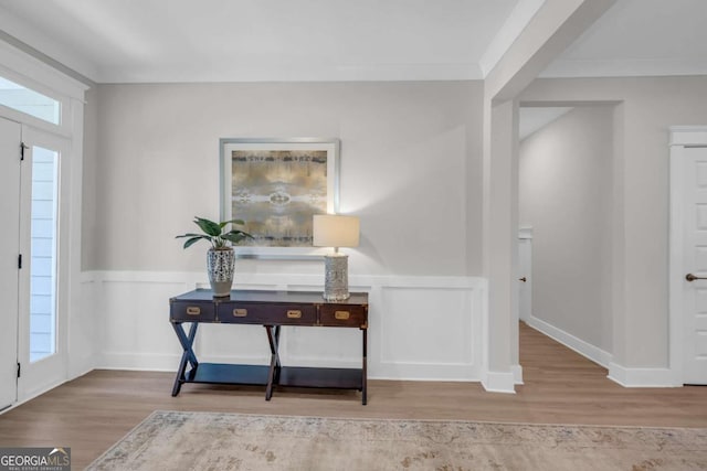 foyer entrance featuring wood-type flooring and ornamental molding