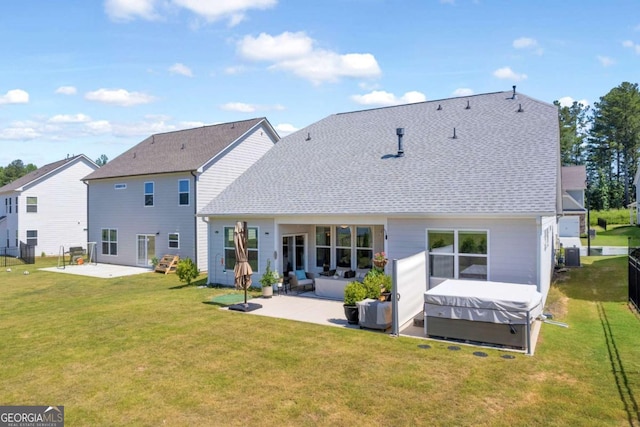 rear view of property featuring outdoor lounge area, a yard, a hot tub, and a patio area