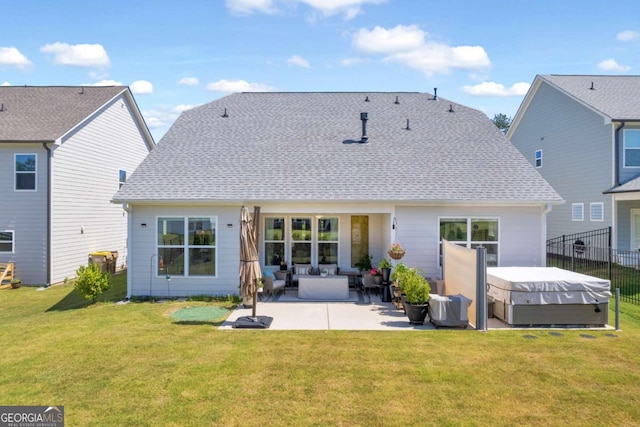 back of property with a yard, a patio, and a hot tub