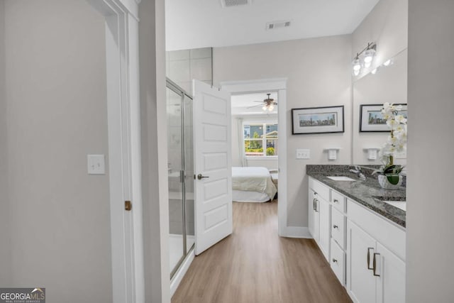 bathroom with ceiling fan, a shower with door, vanity, and wood-type flooring