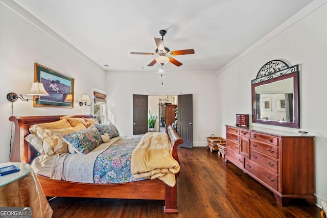 bedroom featuring ceiling fan, crown molding, and dark wood-type flooring