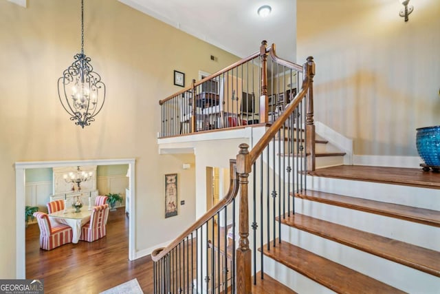 stairs with a chandelier and hardwood / wood-style flooring