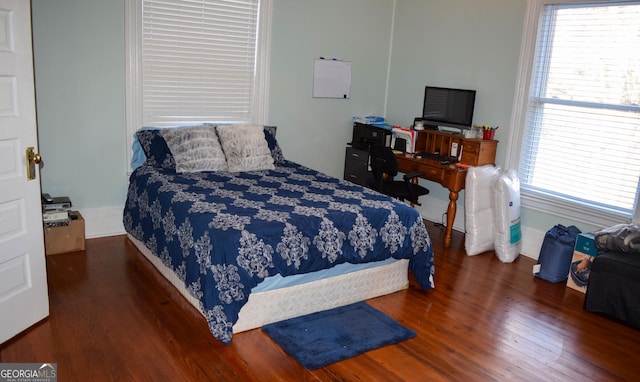 bedroom with dark hardwood / wood-style flooring