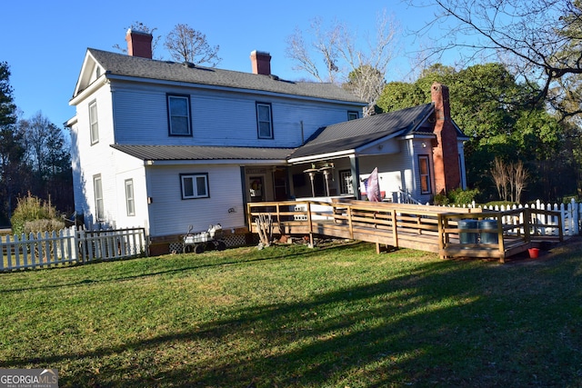 back of property featuring a deck and a yard