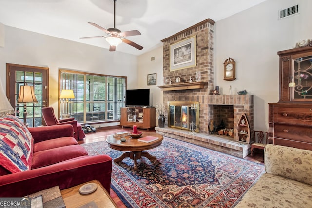 living room with ceiling fan and a brick fireplace